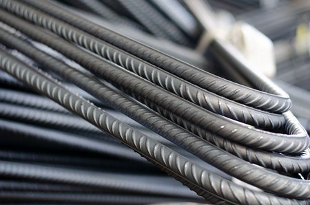 Gebogene, gerippte Bewehrungsstäbe aus Stahl in einer engen Bündelung.