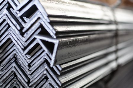 Übereinanderliegende Winkelprofile aus Stahl, eng gestapelt und seitlich fotografiert.