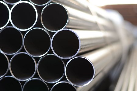 Mehrere übereinandergestapelte Stahlrohre mit offenem Rohrende, in einer Nahaufnahme fotografiert.